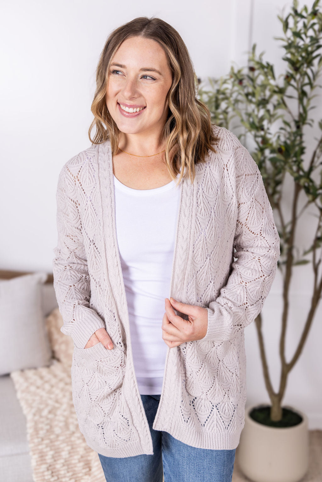 Neutral open knit cardigan with two pockets and airy textured pattern
