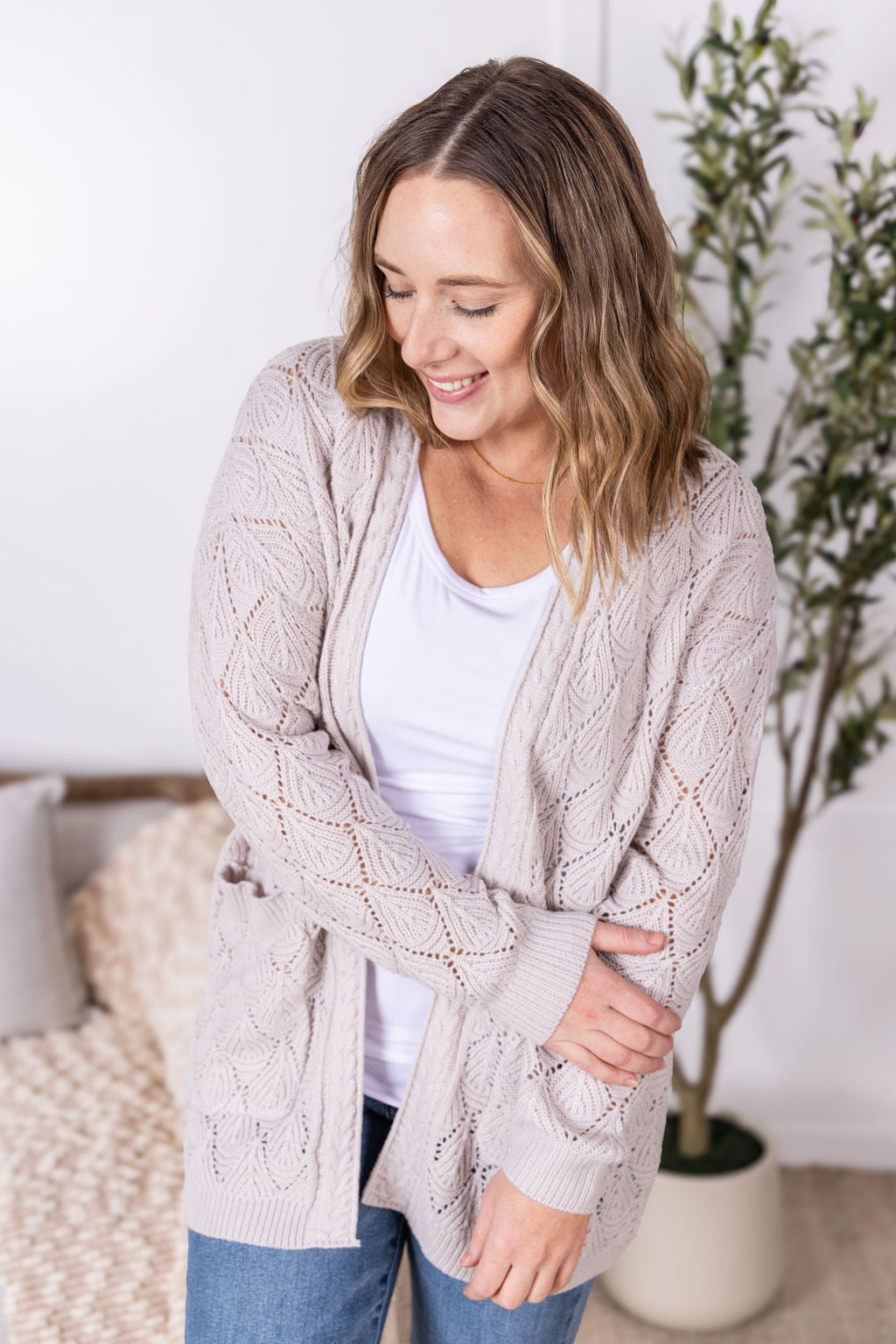 Neutral open knit cardigan with two pockets and airy textured pattern