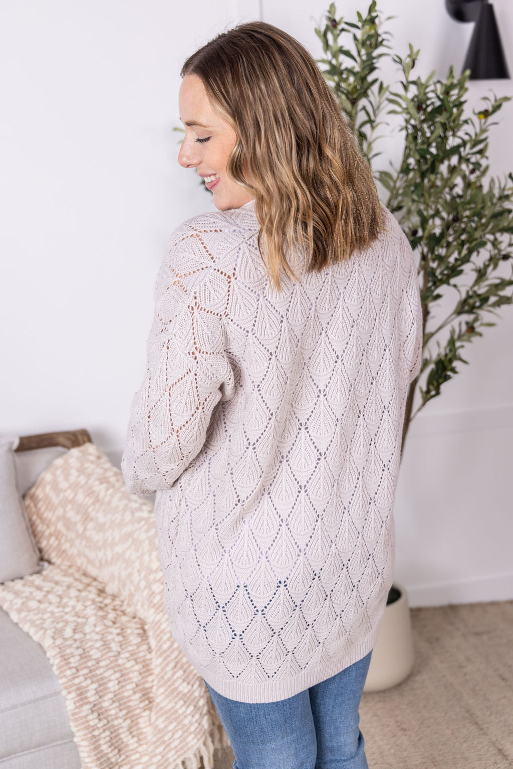 Neutral open knit cardigan with two pockets and airy textured pattern