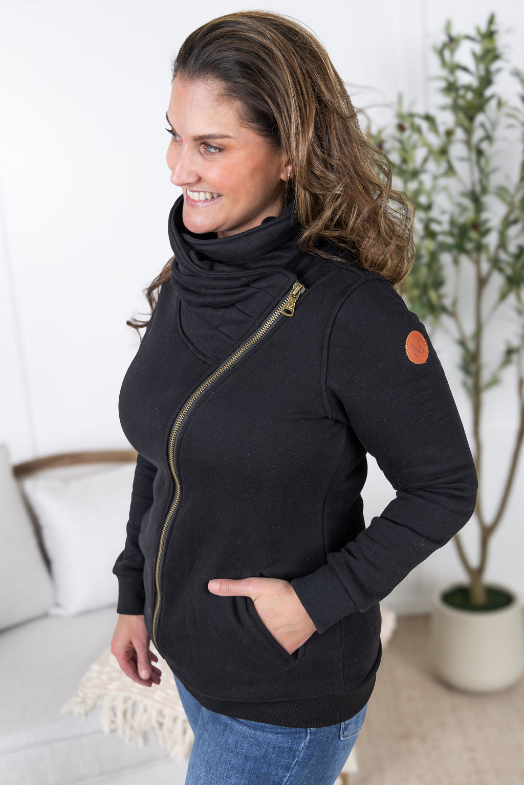 Woman wearing the Quinn ZipUp Cowl in black with asymmetrical zipper