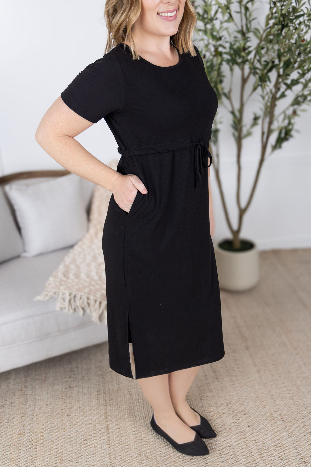 Woman wearing black Gracelynn Midi Dress with tie waist and pockets