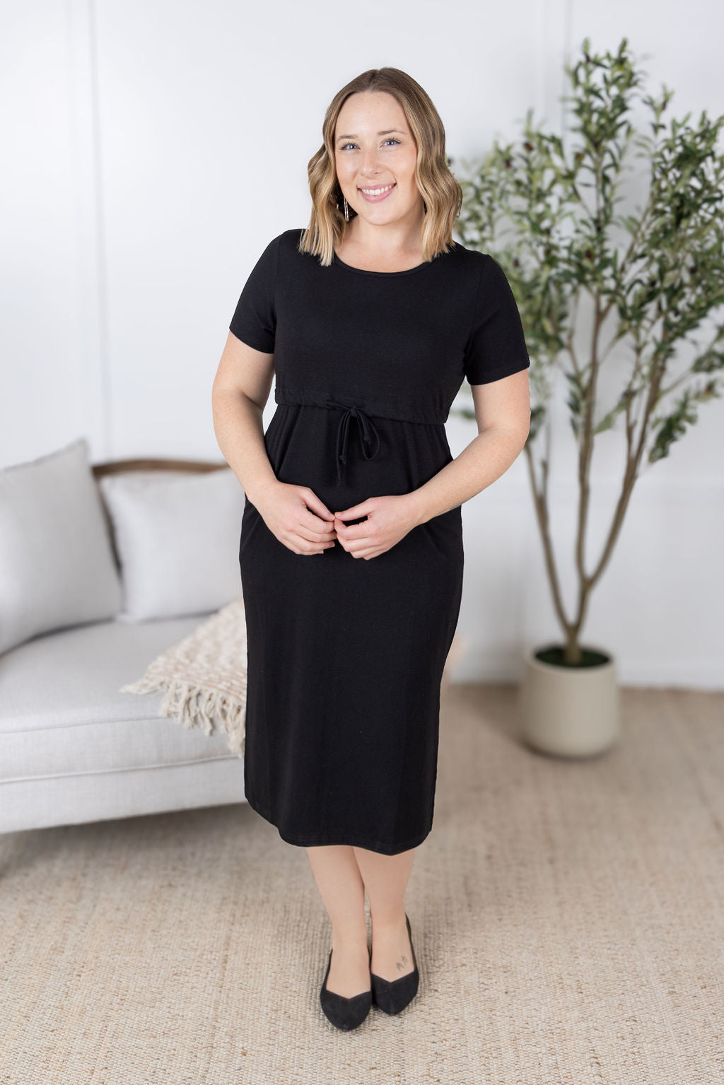 Woman wearing black Gracelynn Midi Dress with tie waist and pockets