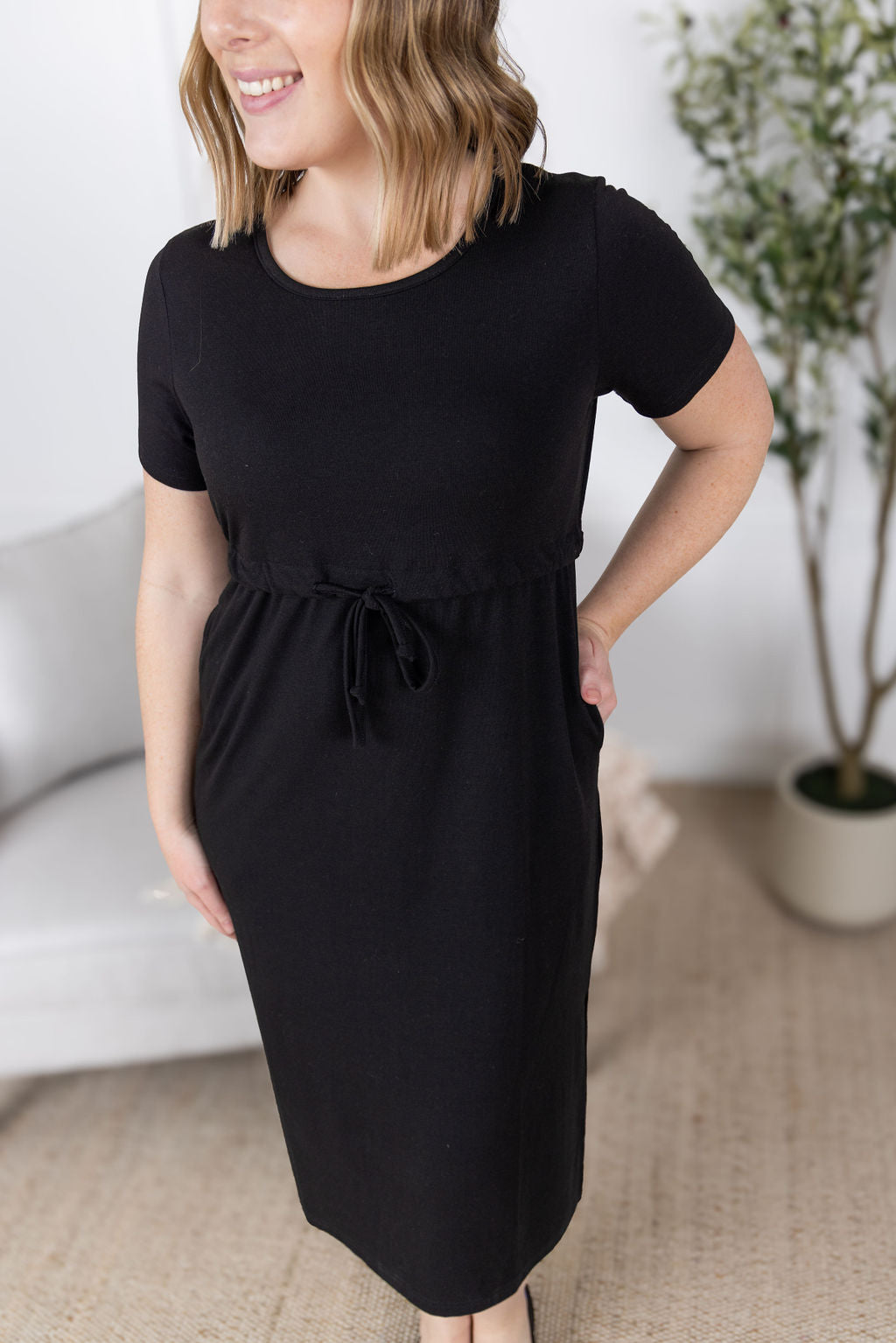 Woman wearing black Gracelynn Midi Dress with tie waist and pockets