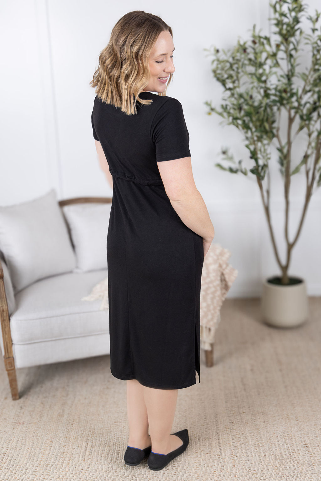 Woman wearing black Gracelynn Midi Dress with tie waist and pockets