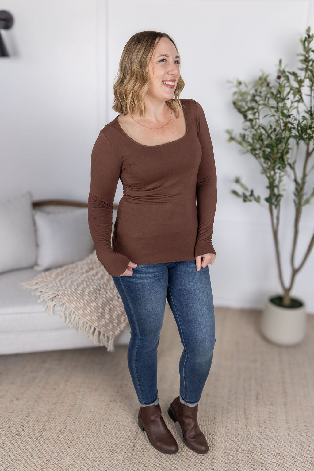 Woman wearing the Alyssa Long Sleeve Top in cocoa brown with jeans