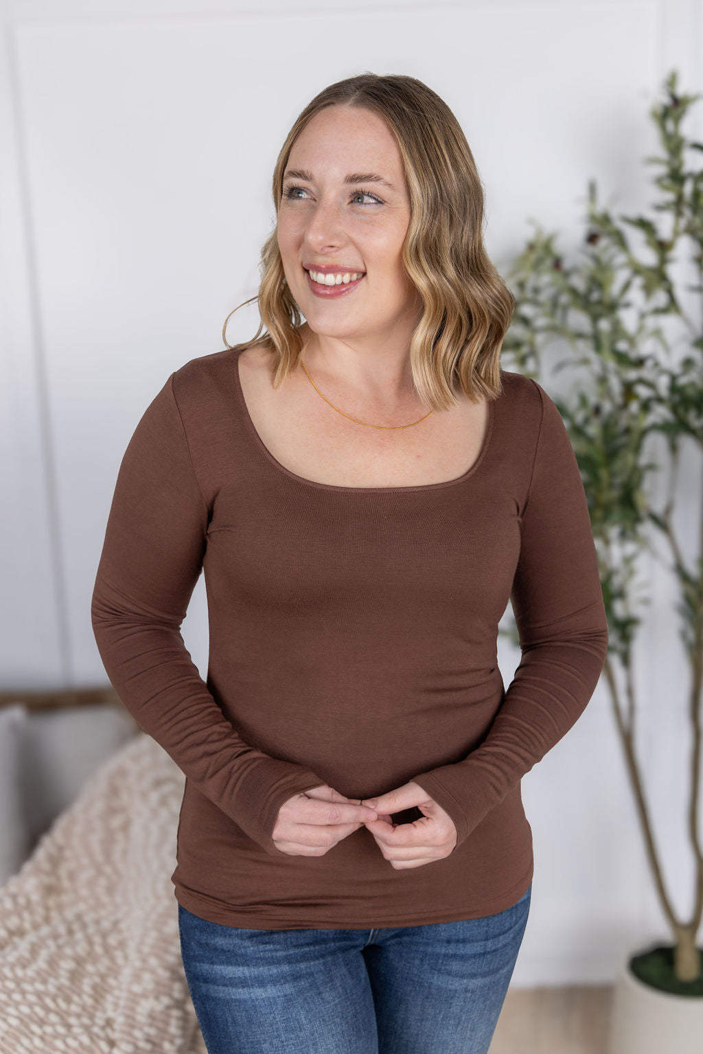 Woman wearing the Alyssa Long Sleeve Top in cocoa brown with jeans