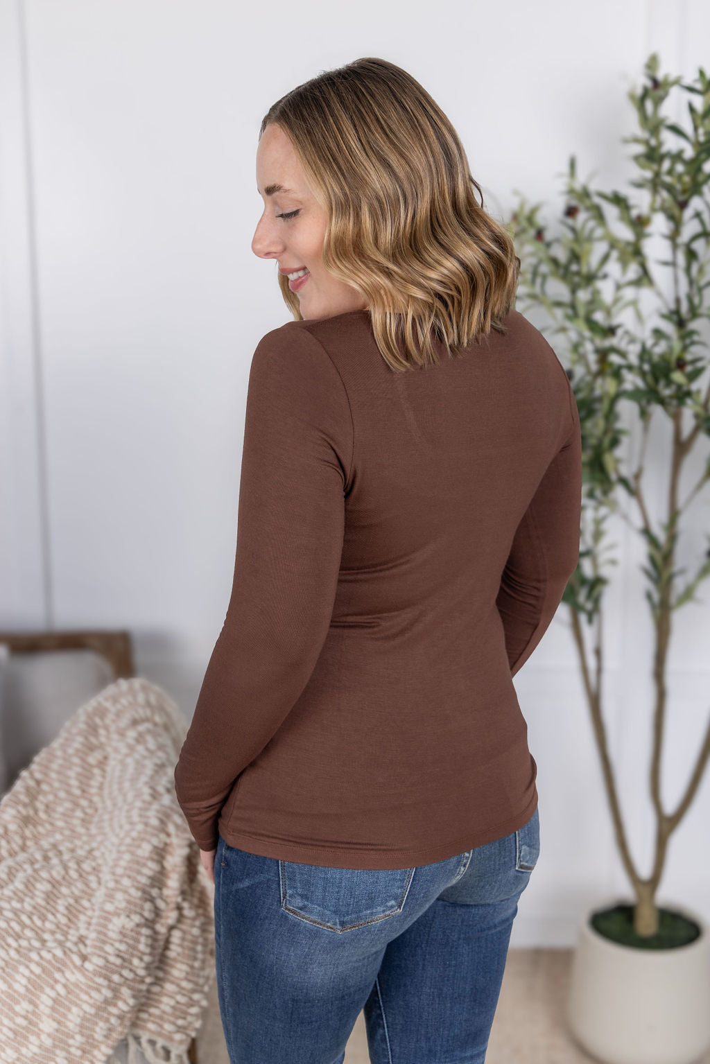 Woman wearing the Alyssa Long Sleeve Top in cocoa brown with jeans