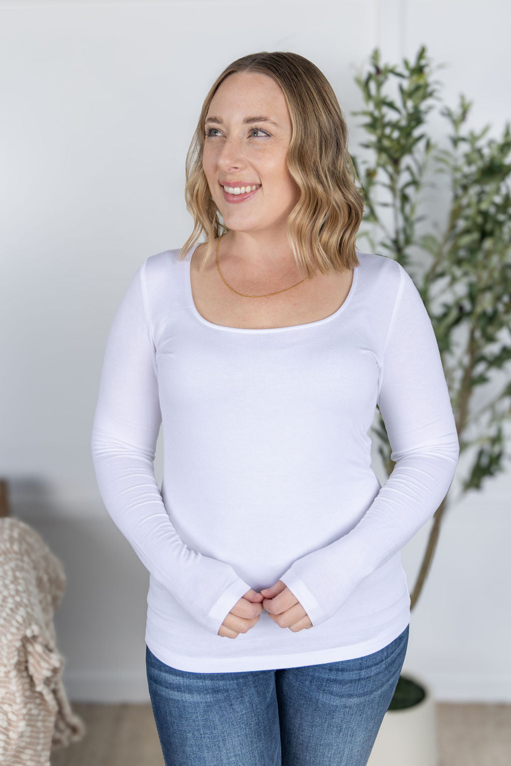 Woman wearing Alyssa Long Sleeve Top in white with scoop neckline