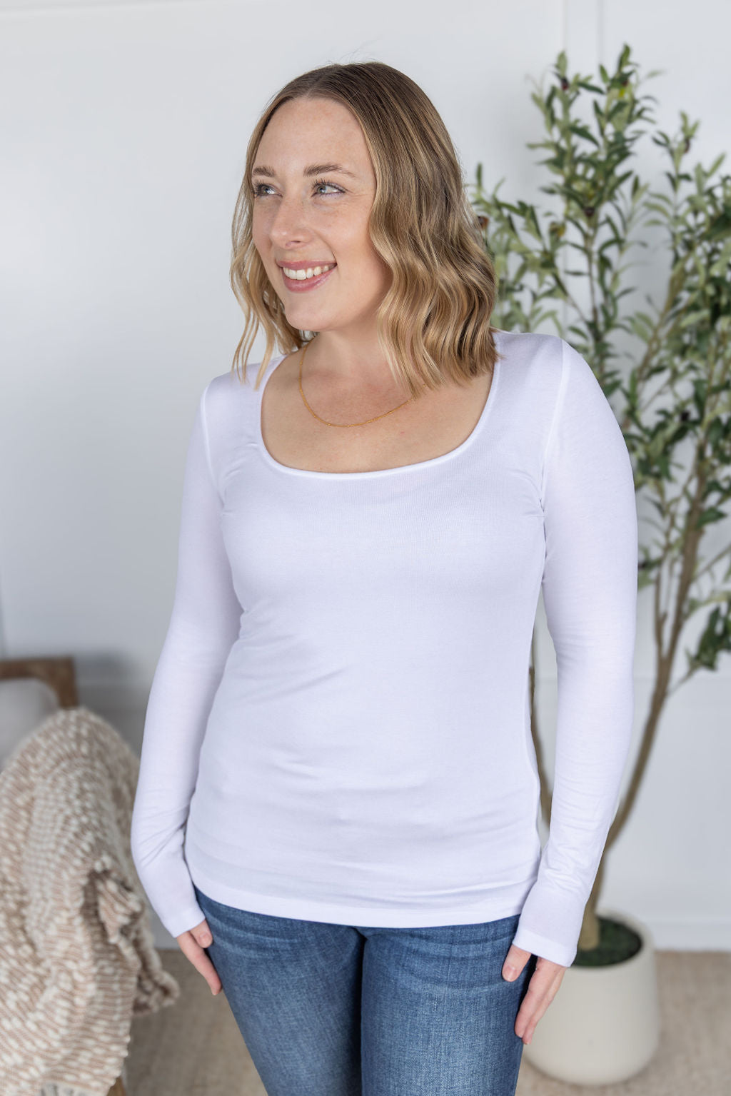 Woman wearing Alyssa Long Sleeve Top in white with scoop neckline