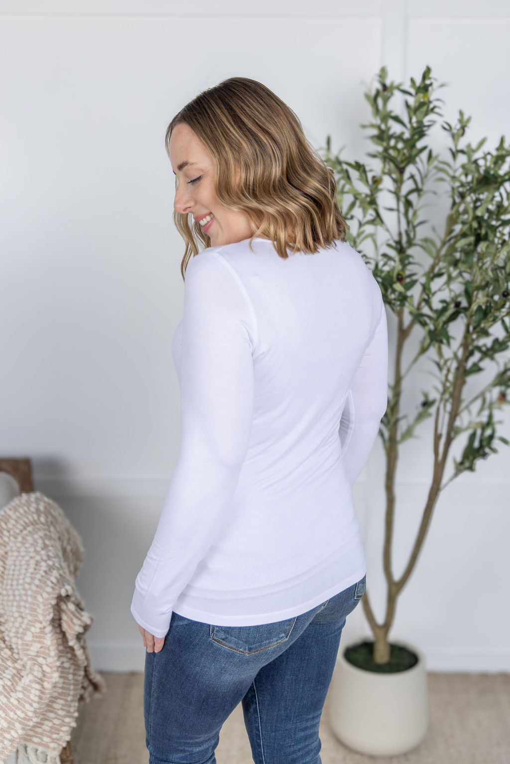 Woman wearing Alyssa Long Sleeve Top in white with scoop neckline