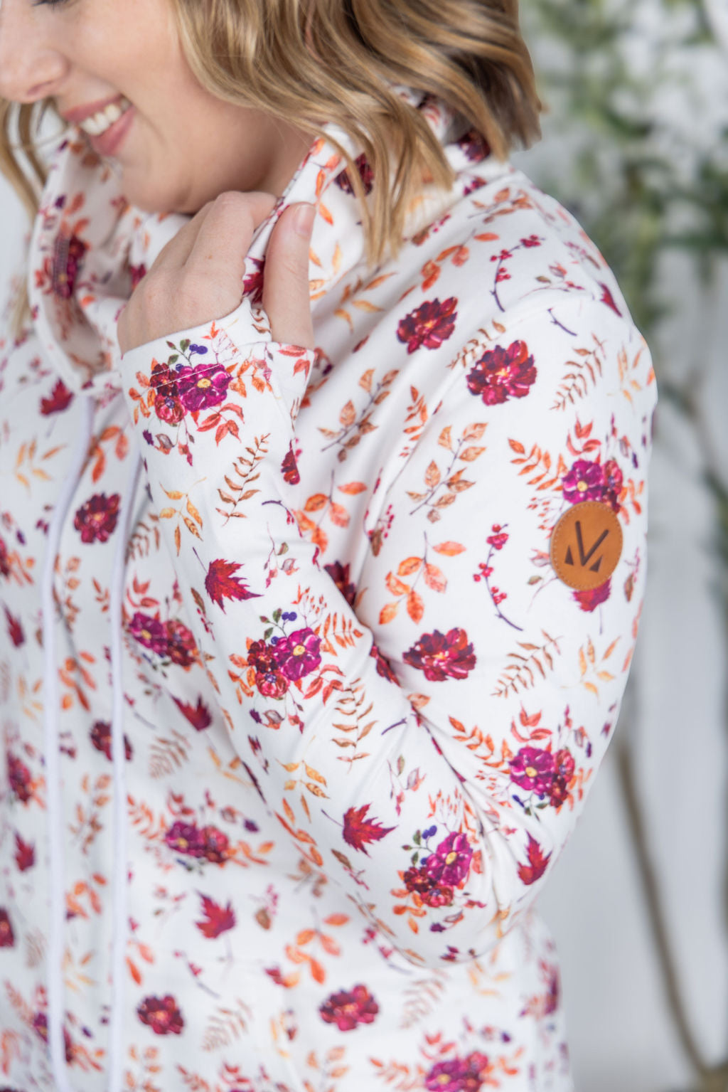 Woman wearing a soft funnel neck sweatshirt in autumn floral print