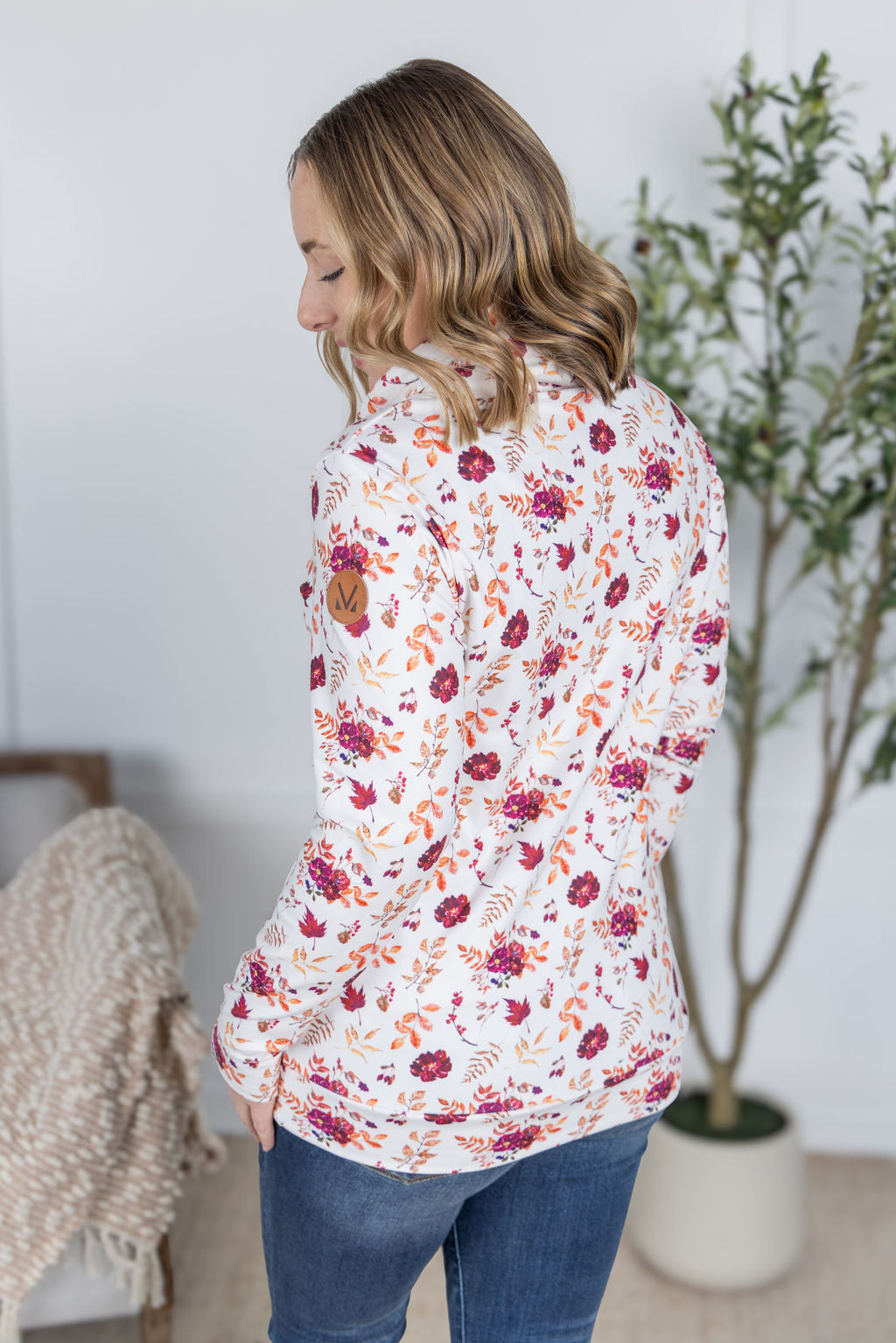 Woman wearing a soft funnel neck sweatshirt in autumn floral print