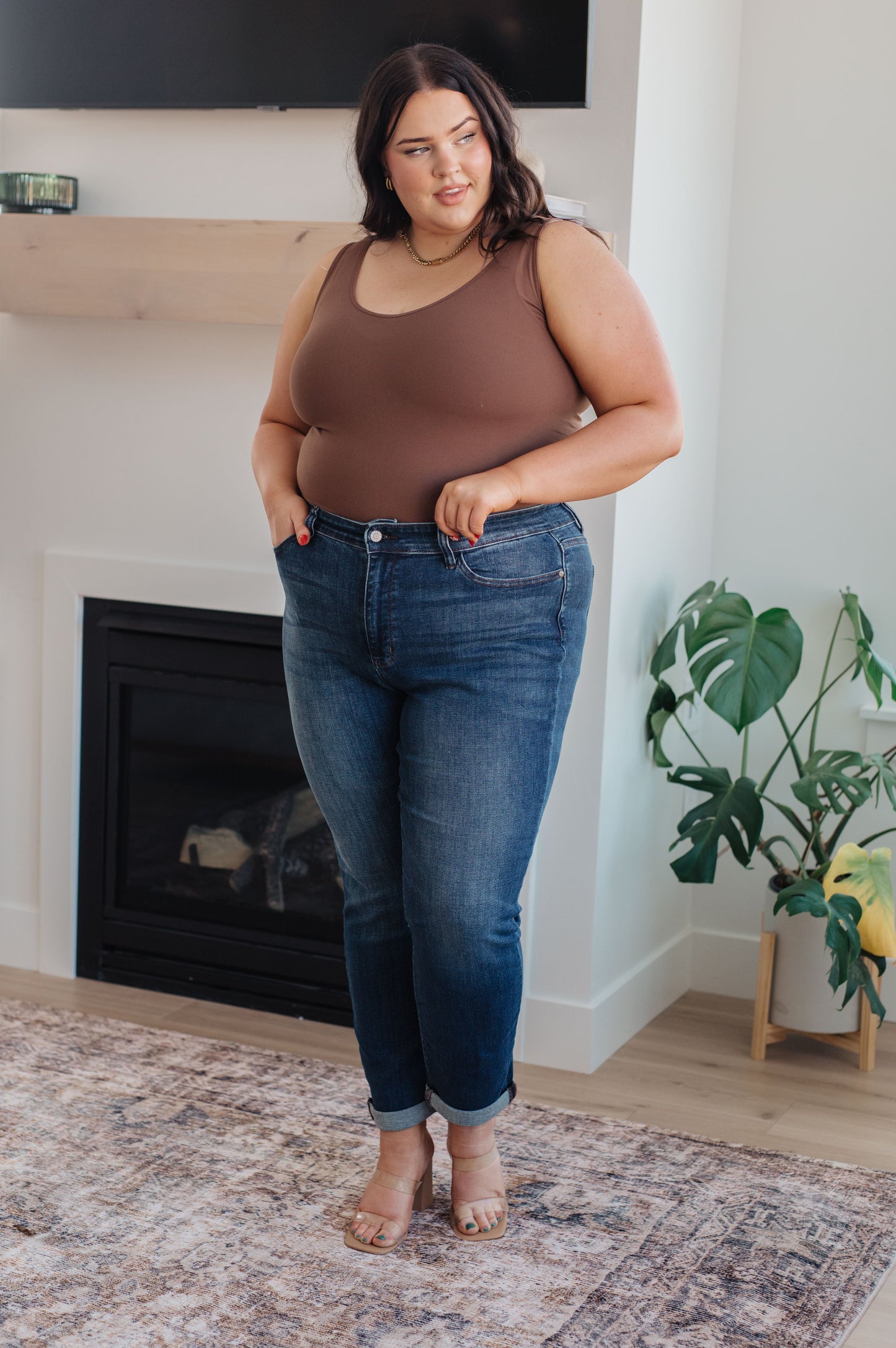 Model wearing dark wash slim fit jeans with cuffed hem and loafers