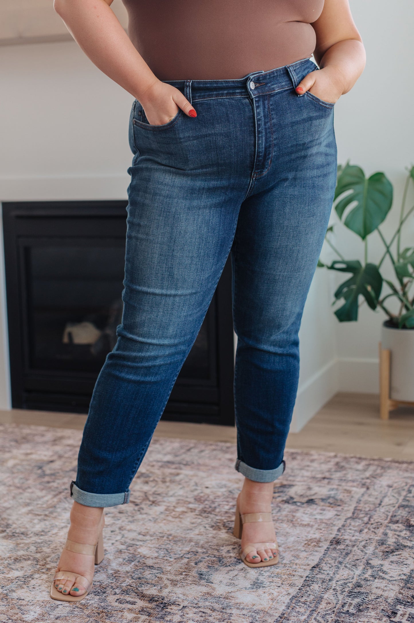 Model wearing dark wash slim fit jeans with cuffed hem and loafers