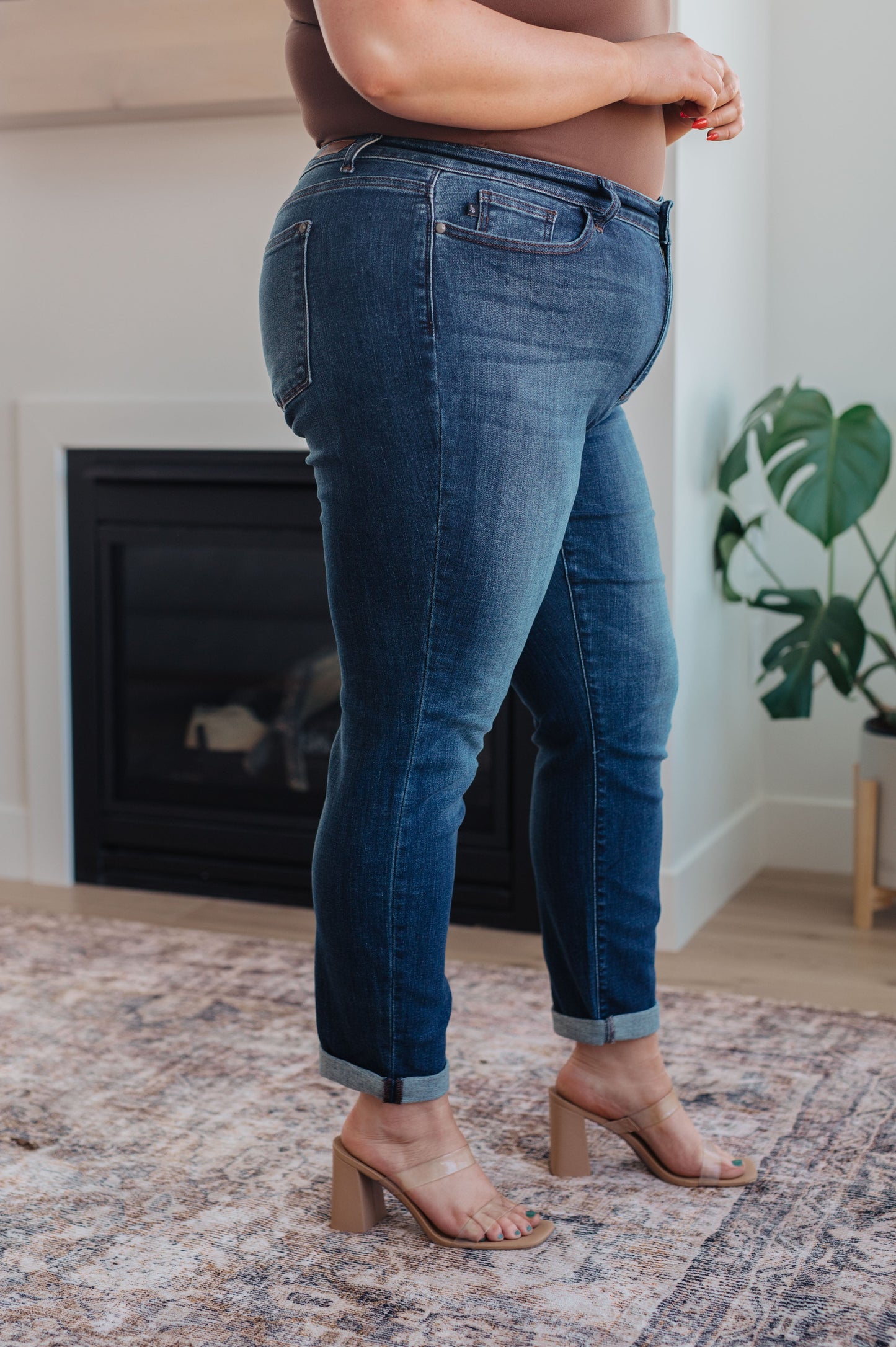 Model wearing dark wash slim fit jeans with cuffed hem and loafers