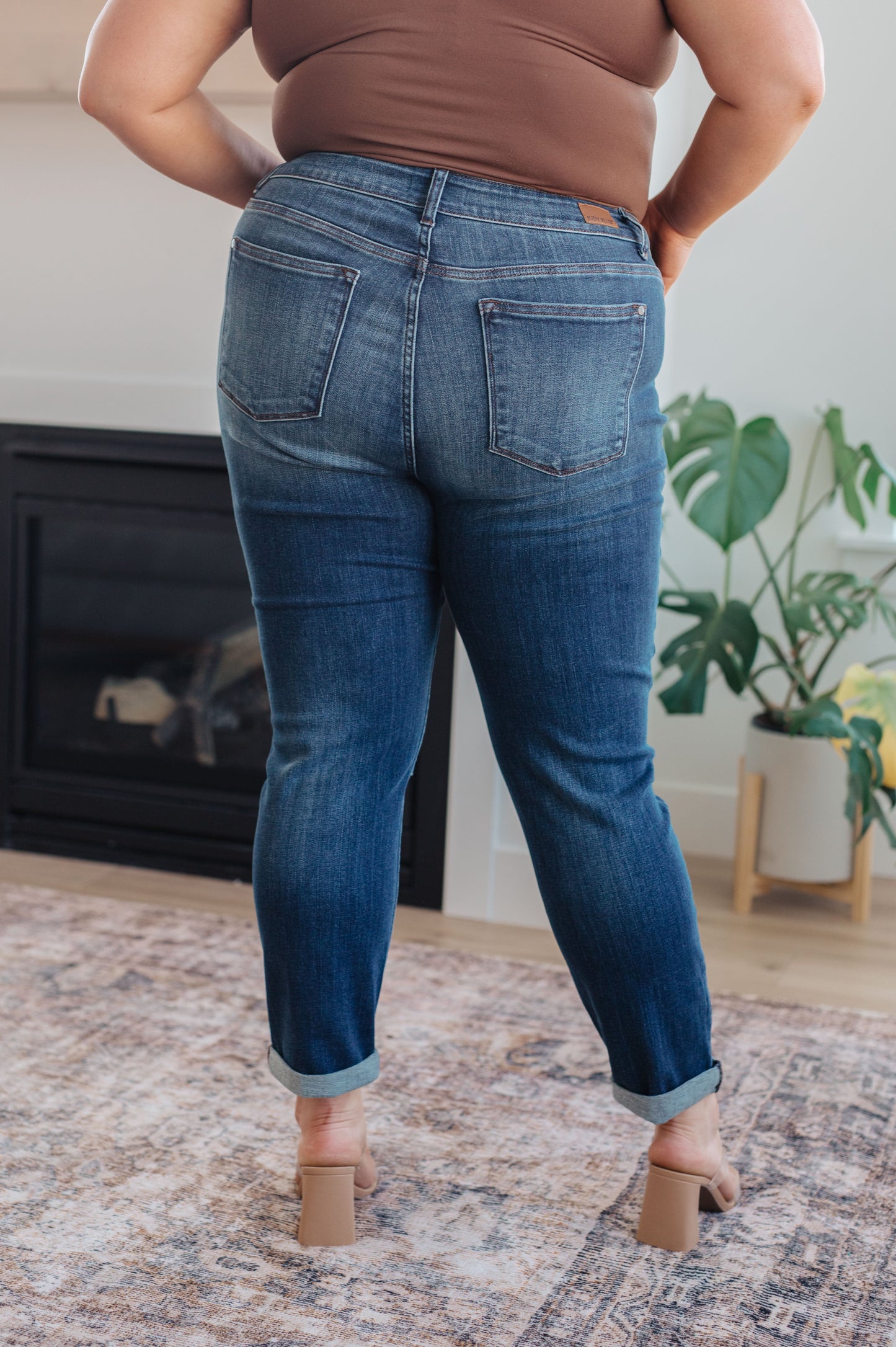 Model wearing dark wash slim fit jeans with cuffed hem and loafers