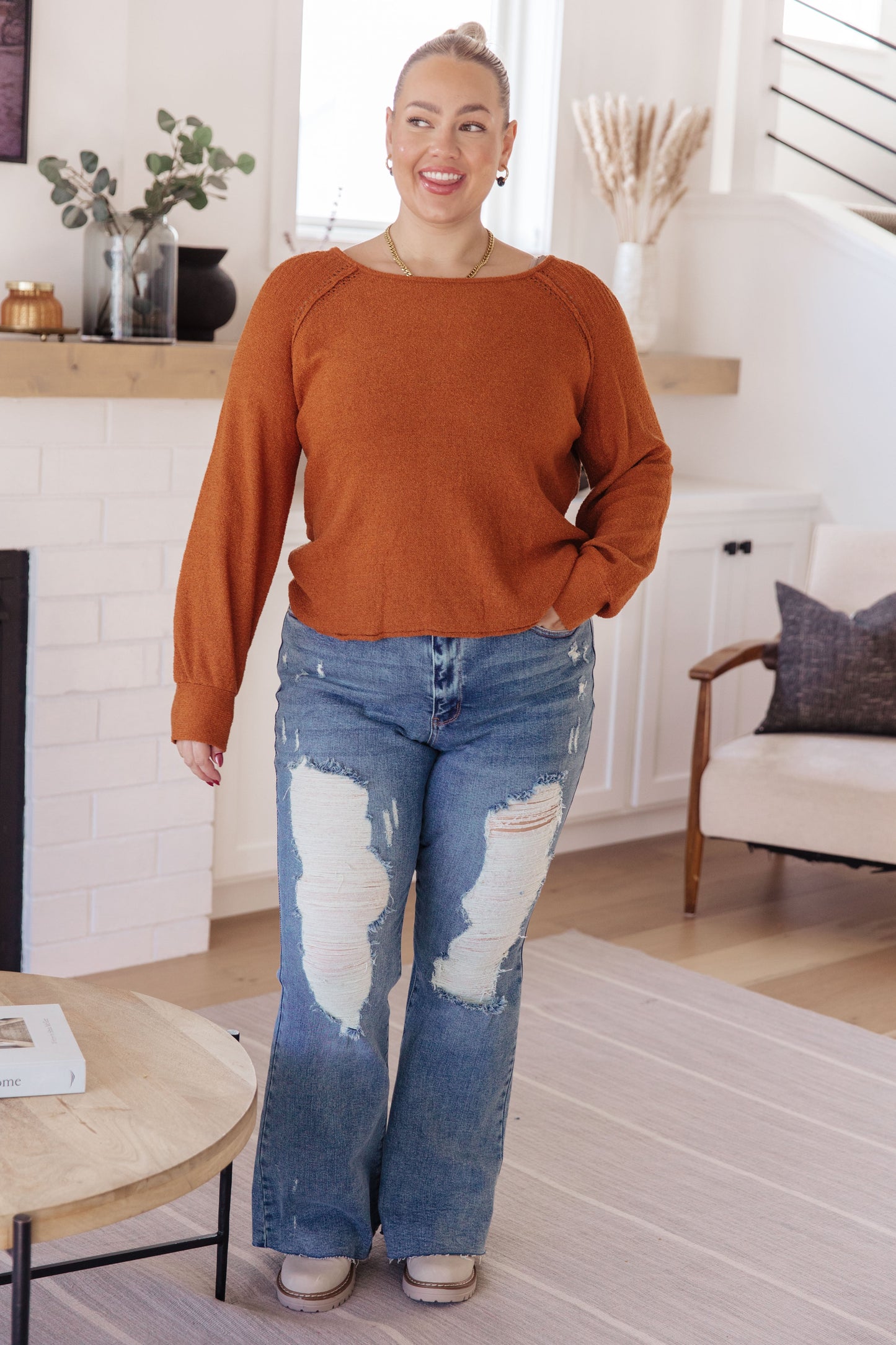 Woman wearing Autumn Glow Pullover Sweater in burnt orange with raglan sleeves and exposed seams.