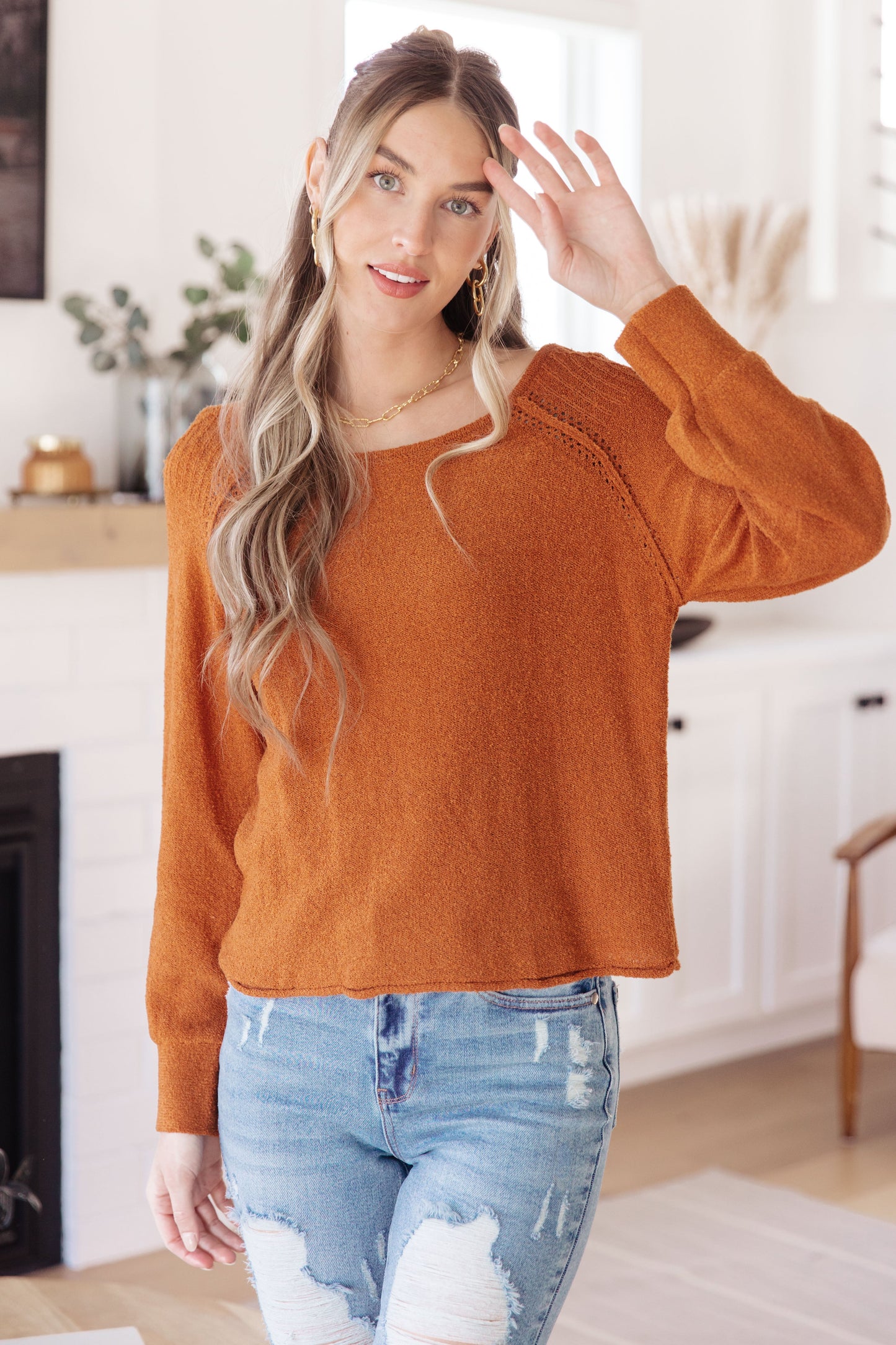 Woman wearing Autumn Glow Pullover Sweater in burnt orange with raglan sleeves and exposed seams.
