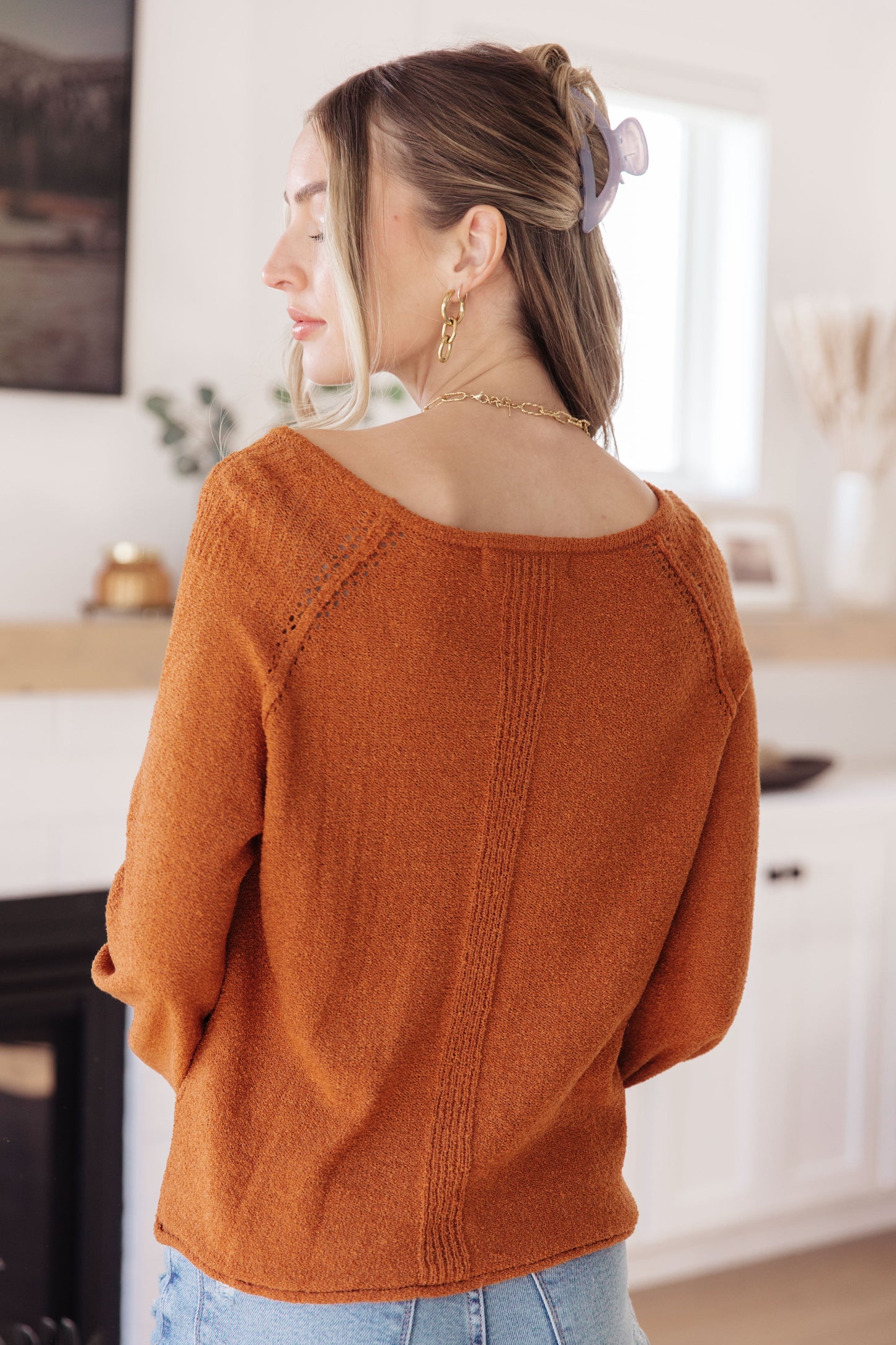 Woman wearing Autumn Glow Pullover Sweater in burnt orange with raglan sleeves and exposed seams.