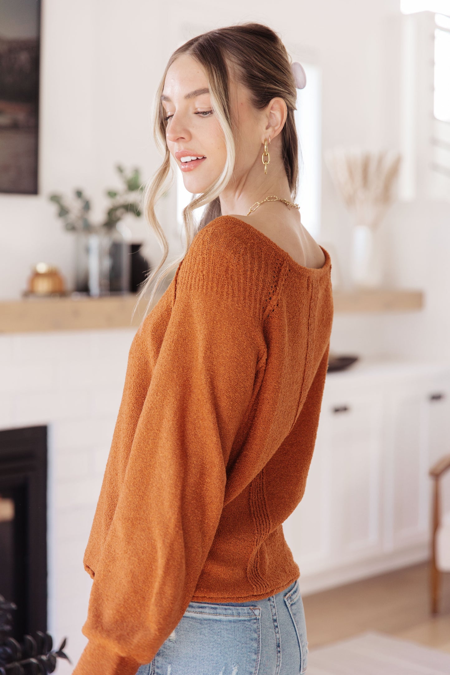 Woman wearing Autumn Glow Pullover Sweater in burnt orange with raglan sleeves and exposed seams.
