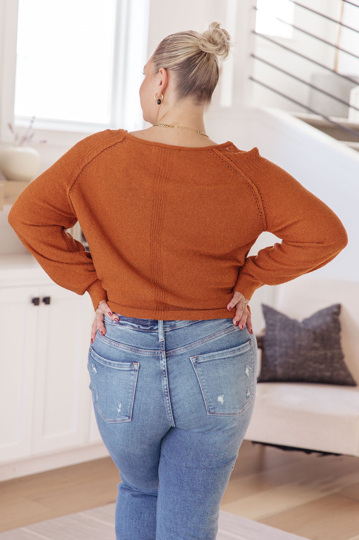 Woman wearing Autumn Glow Pullover Sweater in burnt orange with raglan sleeves and exposed seams.