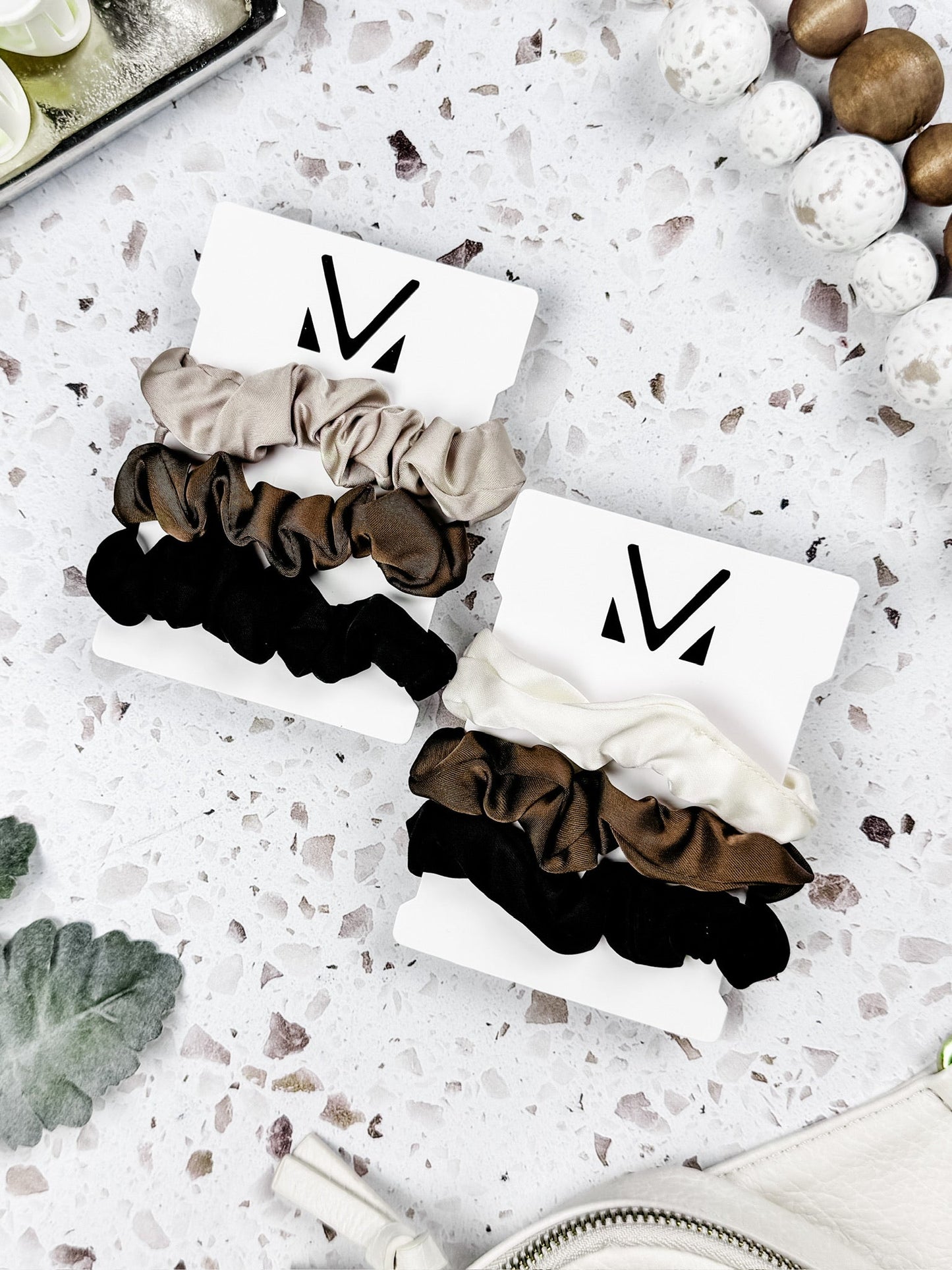 Set of three satin neutral scrunchies in tan, cream, brown, and black
