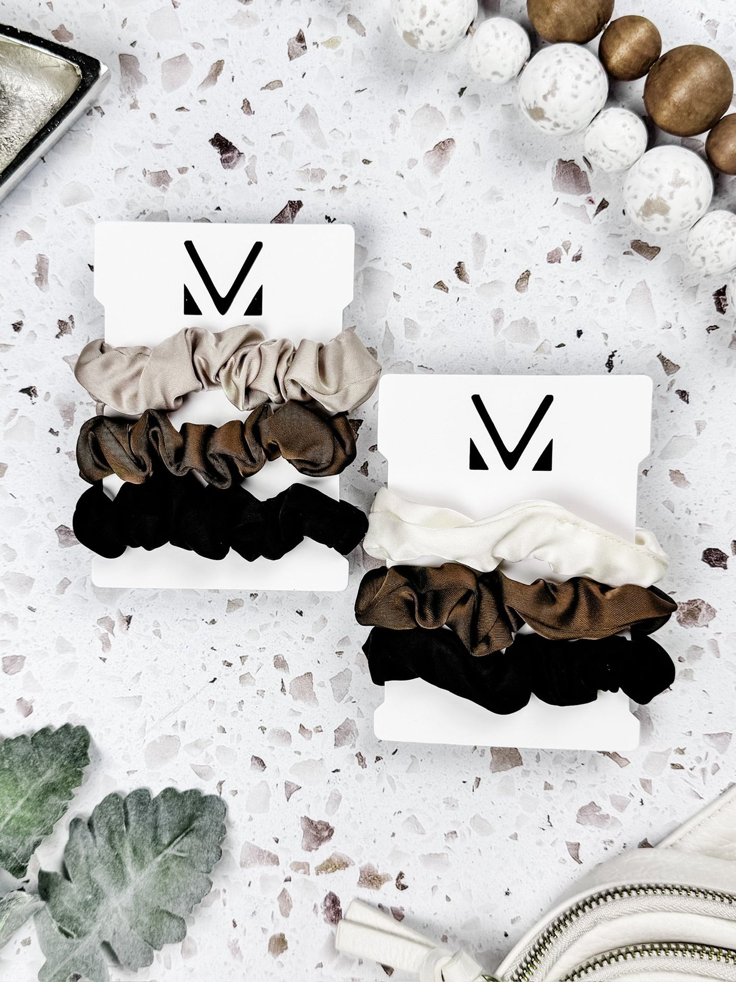 Set of three satin neutral scrunchies in tan, cream, brown, and black