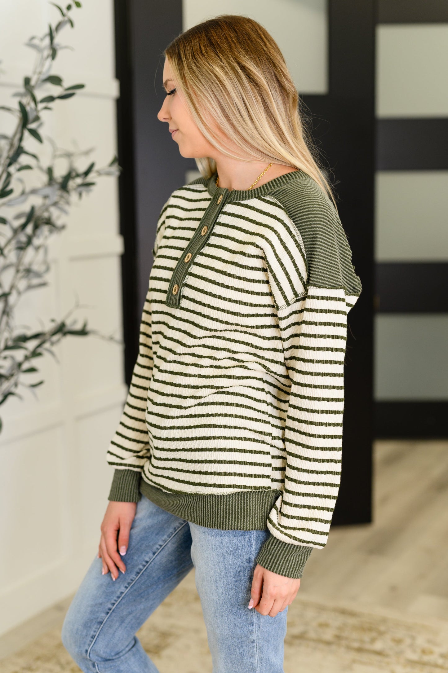 Striped Henley top with contrast green accents, banded hem, and half button closures
