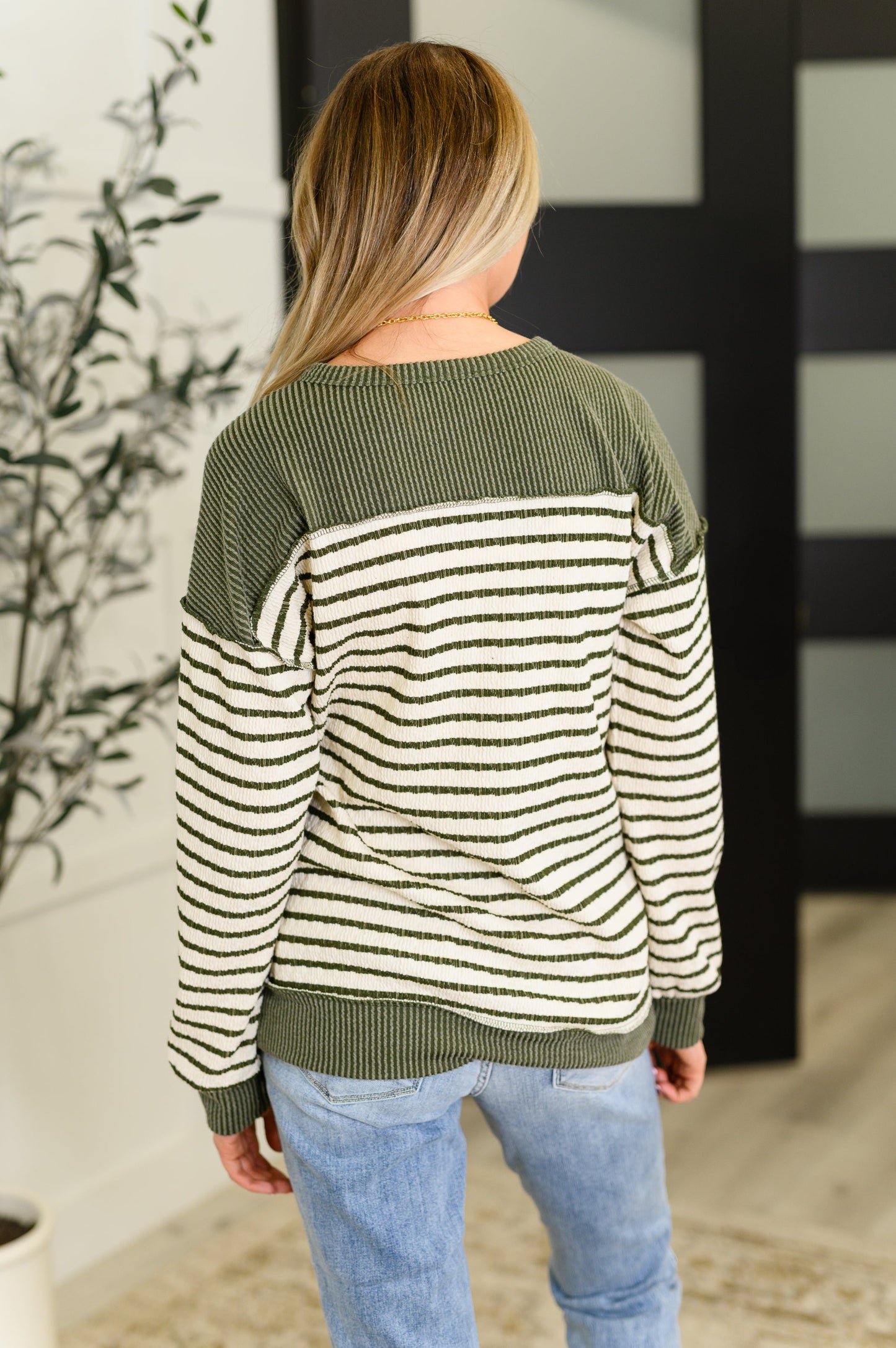 Striped Henley top with contrast green accents, banded hem, and half button closures