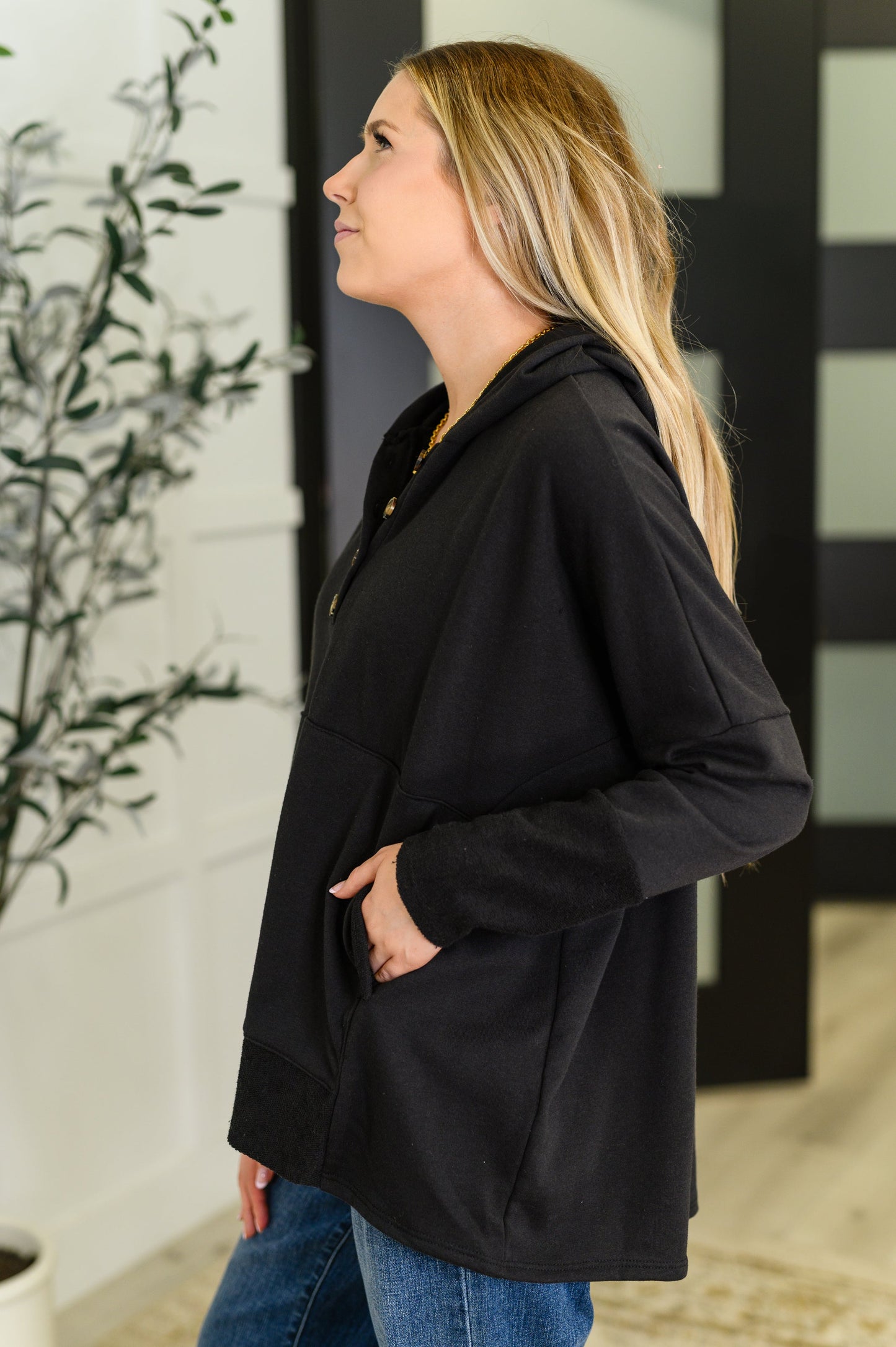 Black Henley pullover hoodie with kangaroo pocket, thumb holes, and contrast details