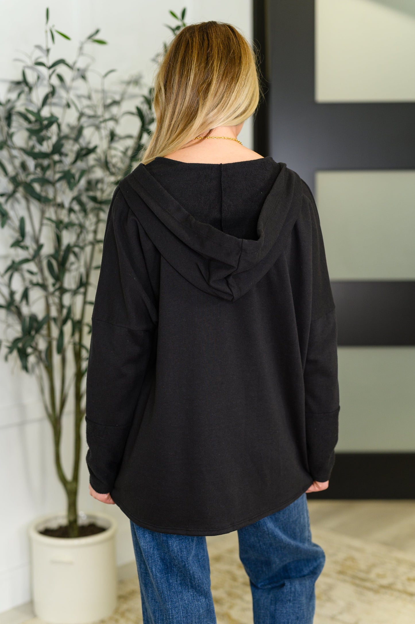 Black Henley pullover hoodie with kangaroo pocket, thumb holes, and contrast details