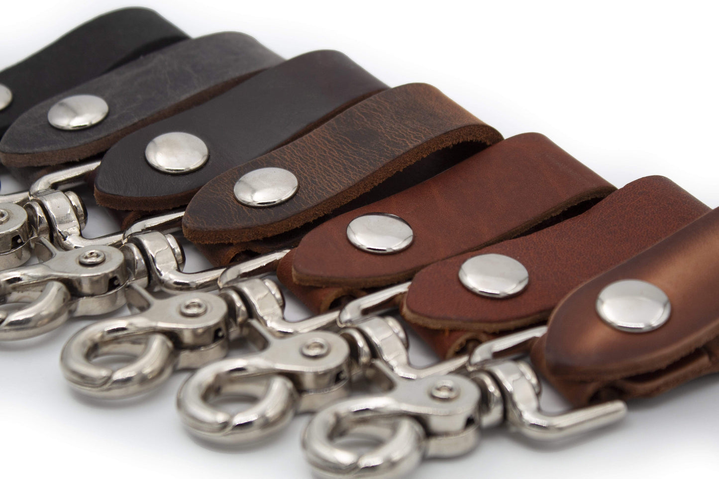 Brown leather straps with silver metal clasps on a white background