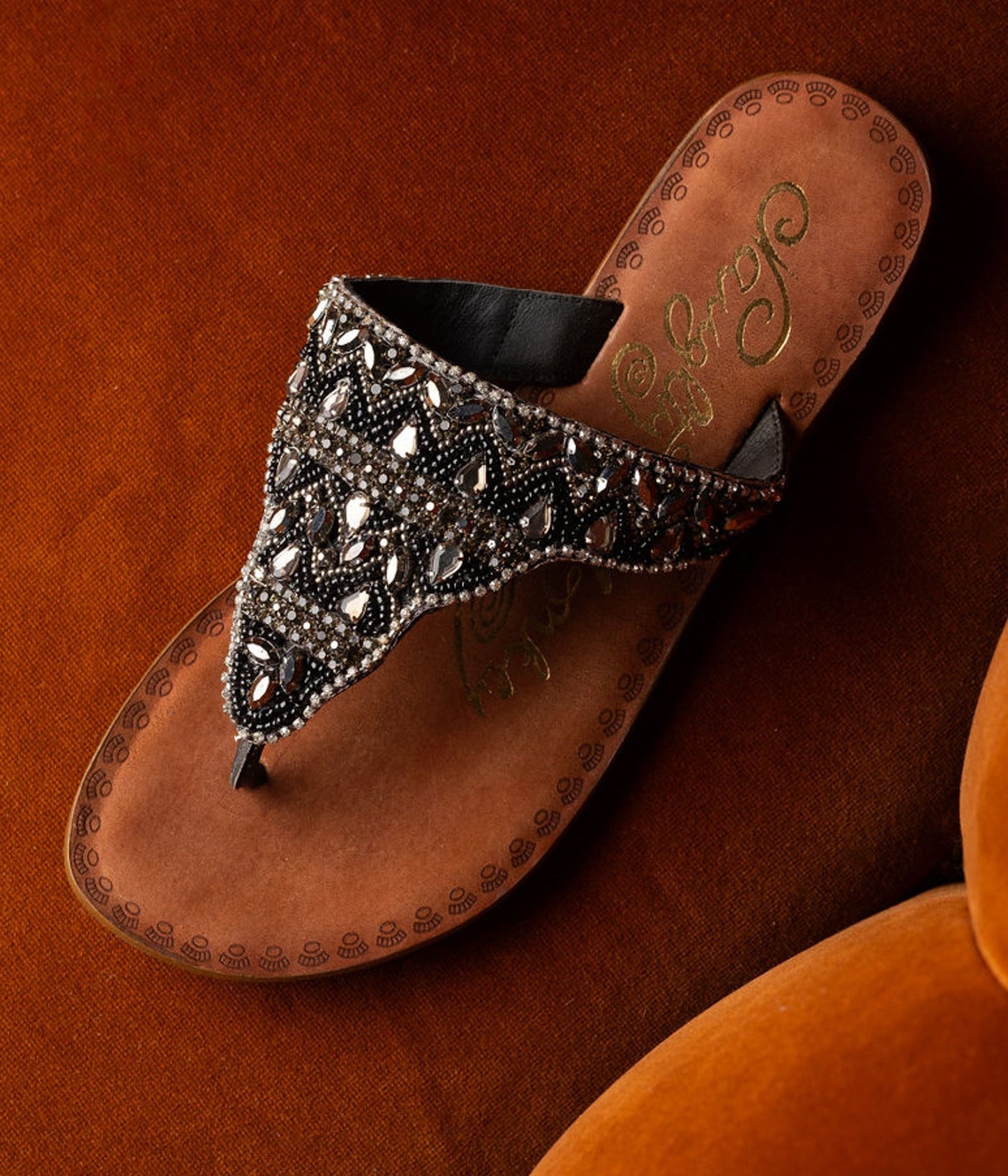 Black jeweled sandals with genuine leather footbed and ornate beaded design