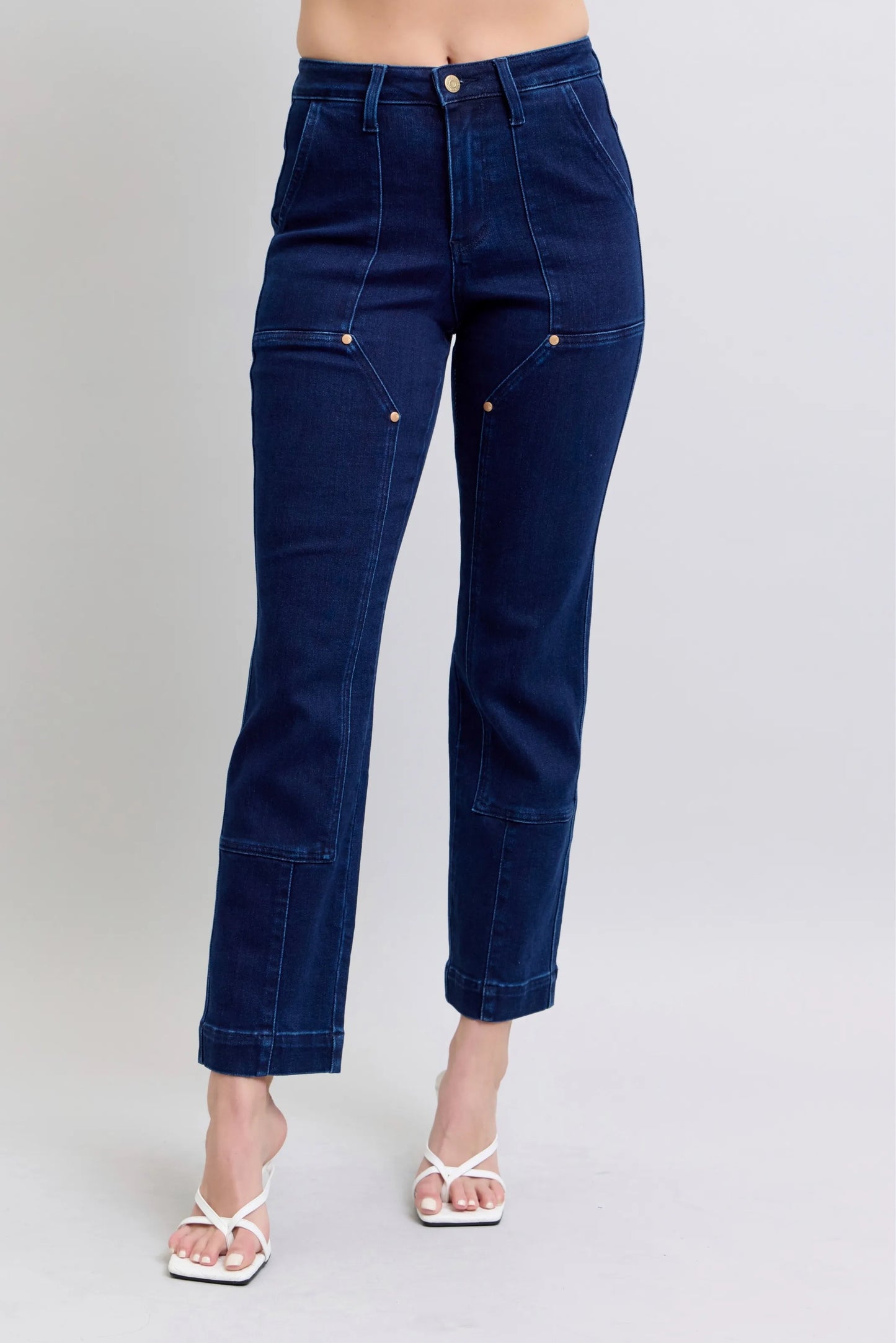 Woman wearing Rowan deep indigo high rise straight leg jeans with star stud details and contrast stitching