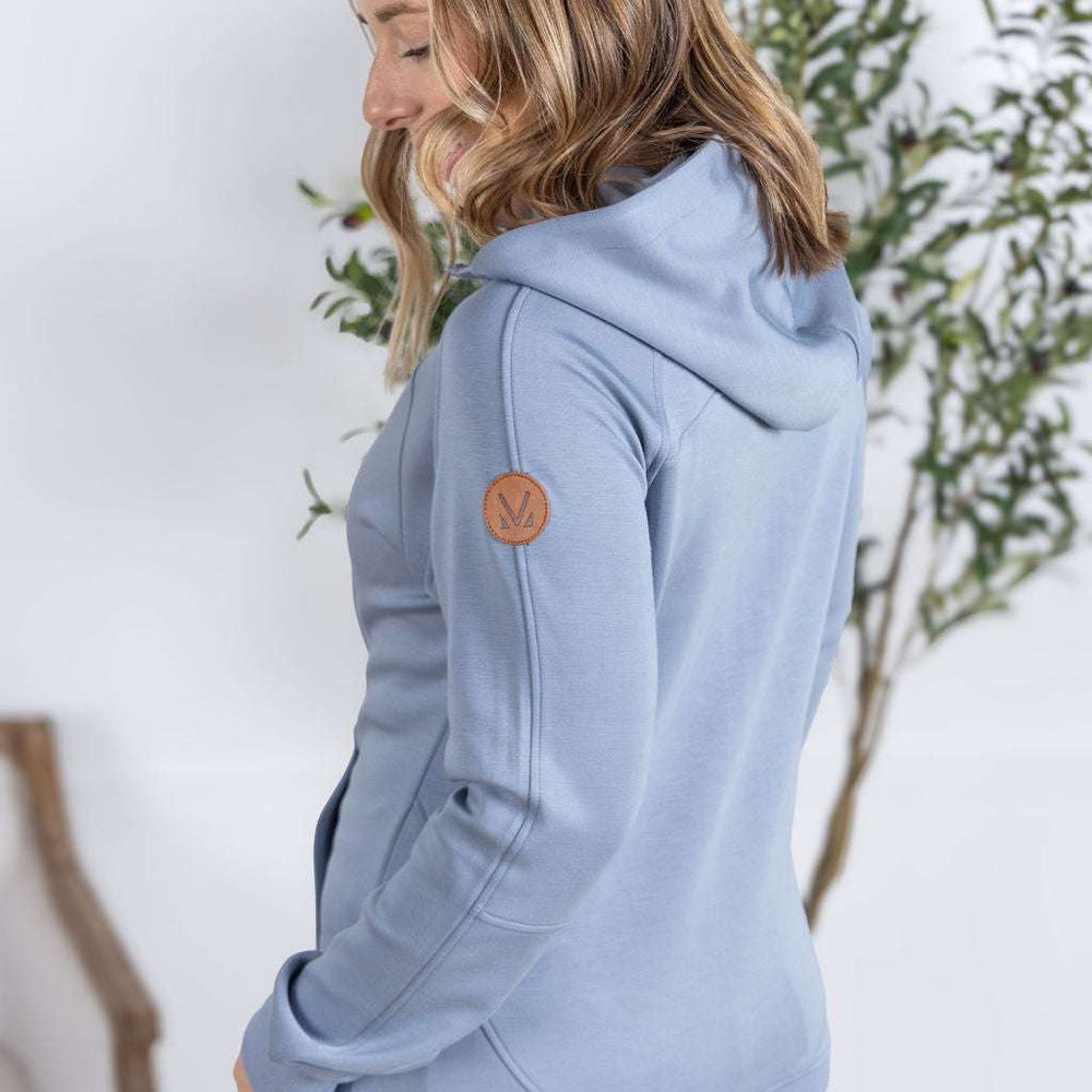 
                  
                    Back View of a model wearing the Scuba FullZip Hoodie in Dusty Blue, featuring a front zipper closure, cozy hood, and relaxed fit.
                  
                