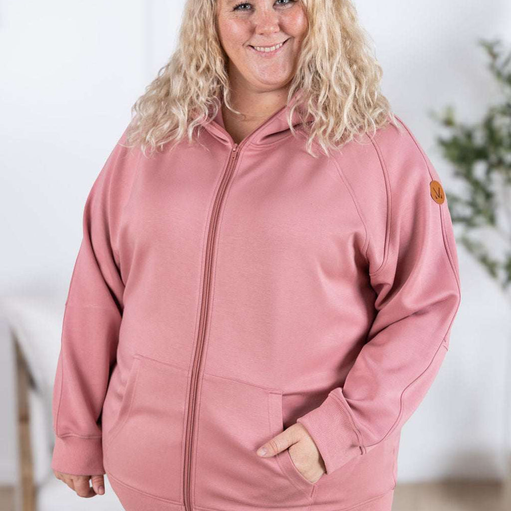 
                  
                    Close-up of a smiling model wearing the Scuba FullZip Hoodie in Rose, featuring a front zipper closure, cozy hood, and relaxed fit.
                  
                