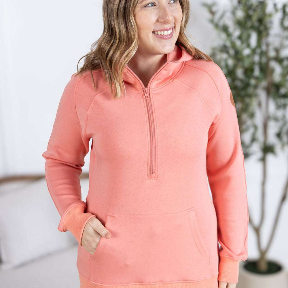 
                  
                    Close-up of a smiling model wearing the Scuba HalfZip Hoodie in Coral, featuring a half-zip neckline, cozy hood, and comfortable relaxed fit
                  
                