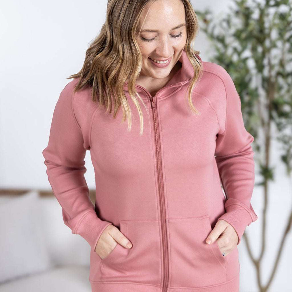 Close-up of a smiling model wearing the Scuba FullZip Hoodie in Rose, featuring a front zipper closure, cozy hood, and relaxed fit.