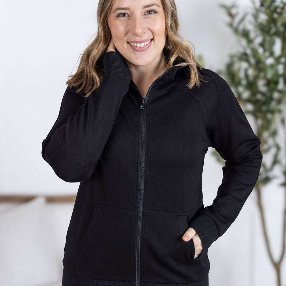 Close-up of a smiling model wearing the Scuba FullZip Hoodie in Black, featuring a front zipper closure, cozy hood, and relaxed fit.
