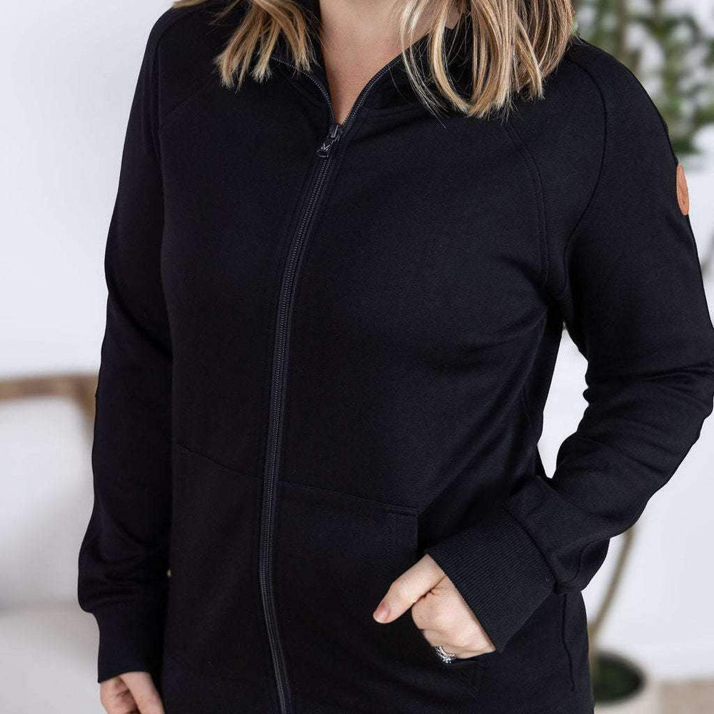 
                  
                    Close-up of a smiling model wearing the Scuba FullZip Hoodie in Black, featuring a front zipper closure, cozy hood, and relaxed fit.
                  
                