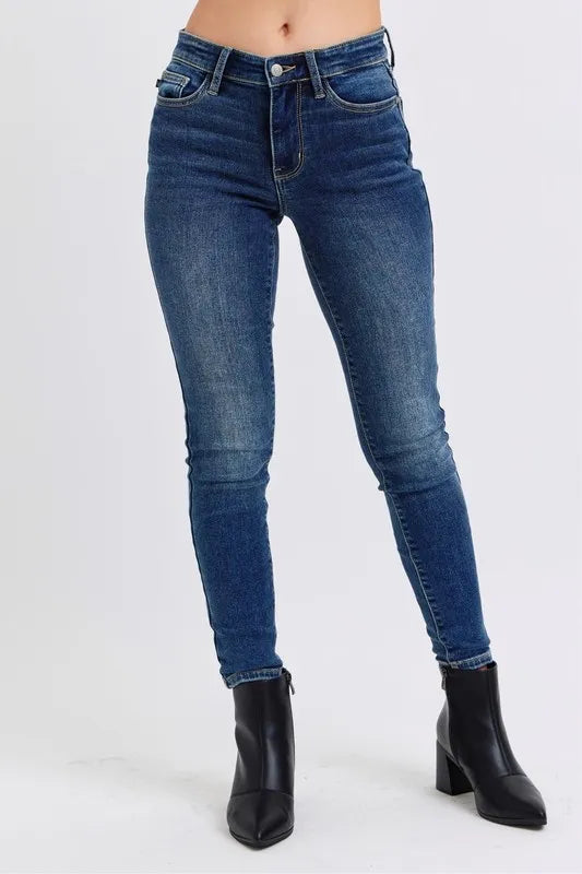 Woman wearing Kinsley dark wash mid rise thermal skinny jeans with ankle length and sleek fit