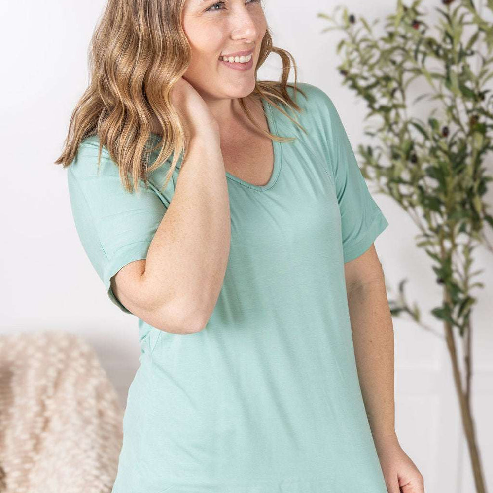 
                  
                    Close-up of a smiling model wearing the Bamboo V Neck Tee in mint by Michelle Mae, featuring a flattering v-neckline, short sleeves, and comfortable relaxed fit
                  
                
