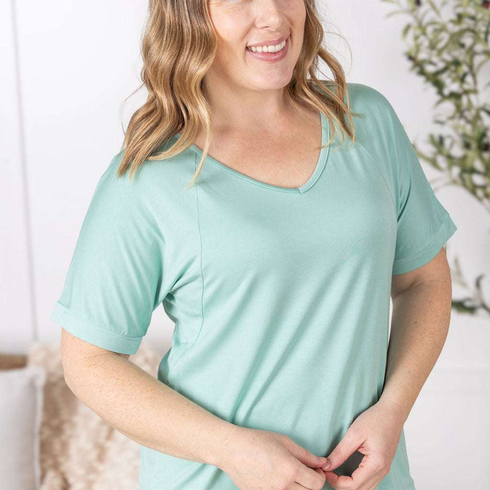 Close-up of a smiling model wearing the Bamboo V Neck Tee in mint by Michelle Mae, featuring a flattering v-neckline, short sleeves, and comfortable relaxed fit