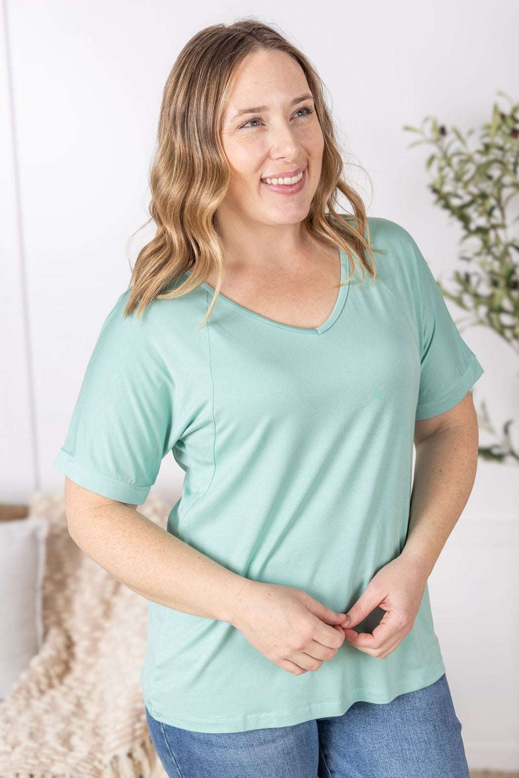 Close-up of a smiling model wearing the Bamboo V Neck Tee in mint by Michelle Mae, featuring a flattering v-neckline, short sleeves, and comfortable relaxed fit
