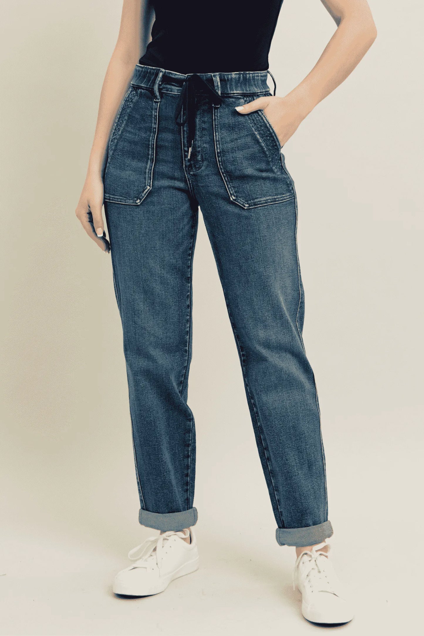 Woman wearing Adler vintage wash high waisted utility jeans with drawstring waist and front patch pockets