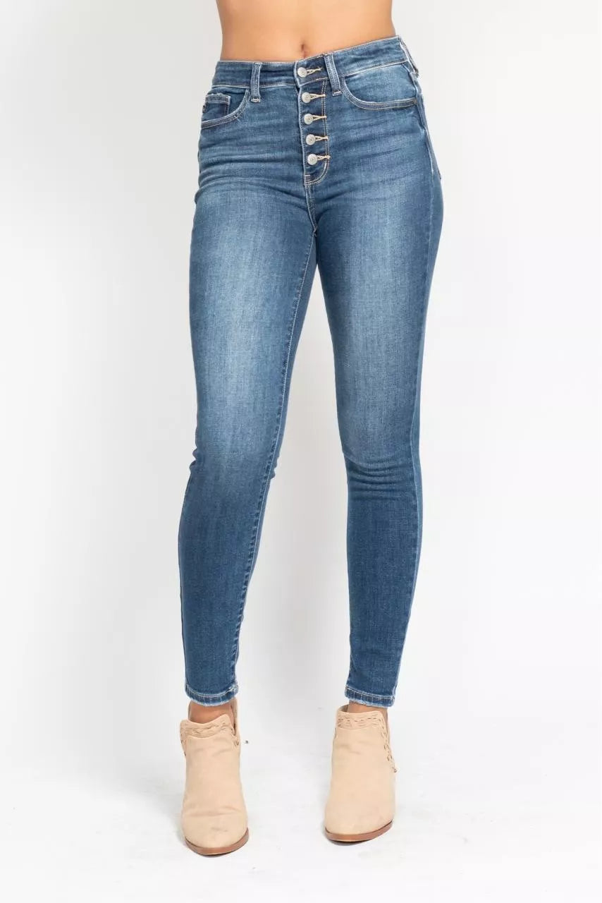 Woman wearing Elodie medium wash high rise button fly skinny jeans with exposed button fly and ankle length