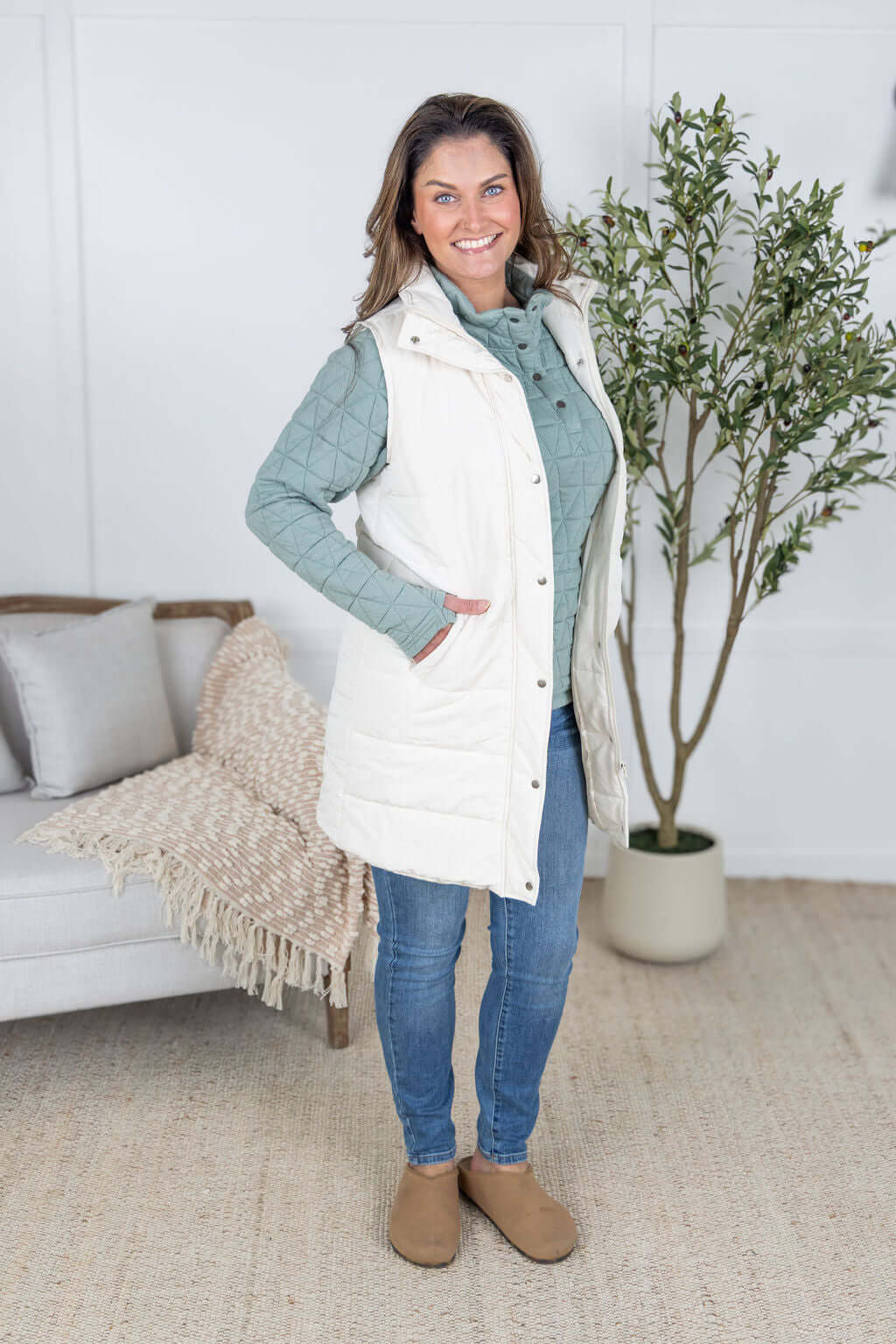 Model wearing the Harlow Long Vest in cream with front pockets and quilted texture