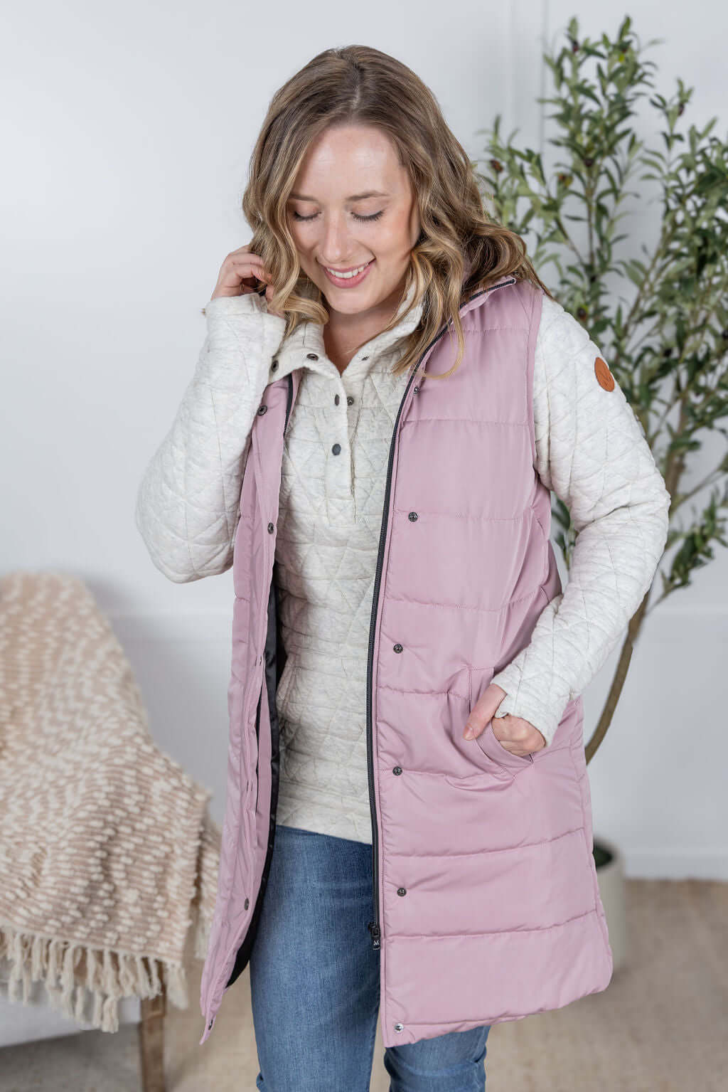 Model wearing the Harlow Long Vest in blush pink with zipper and snap closure