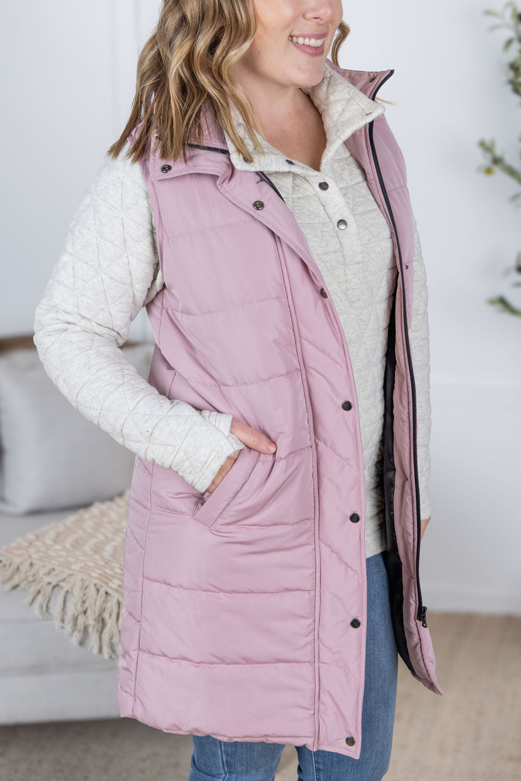 Model wearing the Harlow Long Vest in blush pink with zipper and snap closure