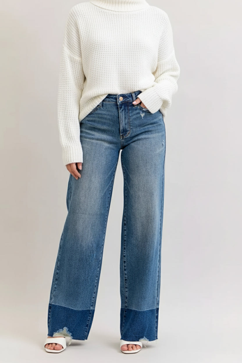 Woman wearing Bristol two-tone high waisted wide leg jeans with raw hem and light wash finish and a comfy white sweater